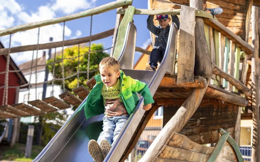 Kinder auf einer Rutsche im Außenspielplatz des Kinderhauses Bopfingen