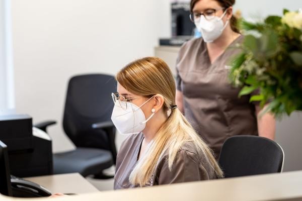 Zwei Arzthelferinnen in einer Zahnarztpraxis arbeiten am Empfang
