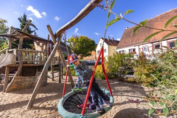 Ein Kind spielt auf einer Schaukel im Außenbereich des Kinderhauses Bopfingen