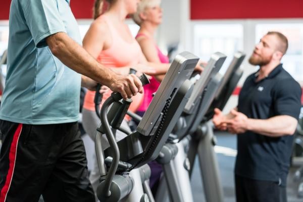 Personen auf Geräten in einem Fitnessstudio als Symbolbild für die Rubrik Prävention & Fitness