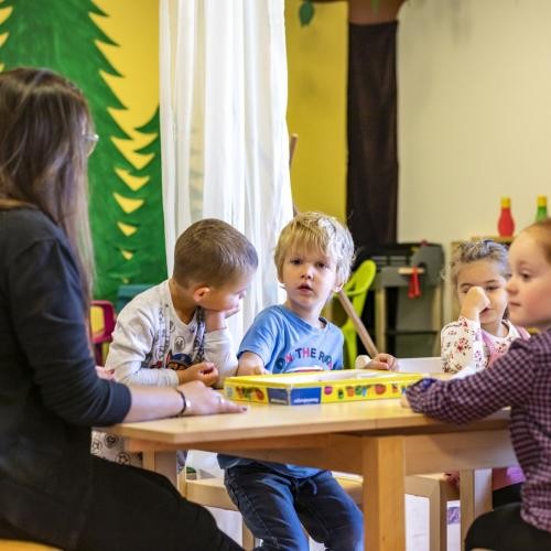 Erzieherin beim Spielen mit Kindern in einer Betreuungseinrichtung